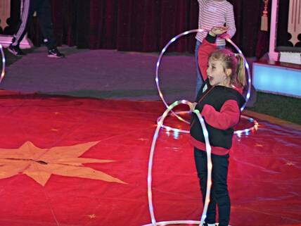 Die Schülerinnen zeigen Übungen mit dem Hula-Hoop-Reifen.