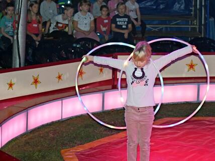 Die Schülerinnen zeigen Übungen mit dem Hula-Hoop-Reifen.